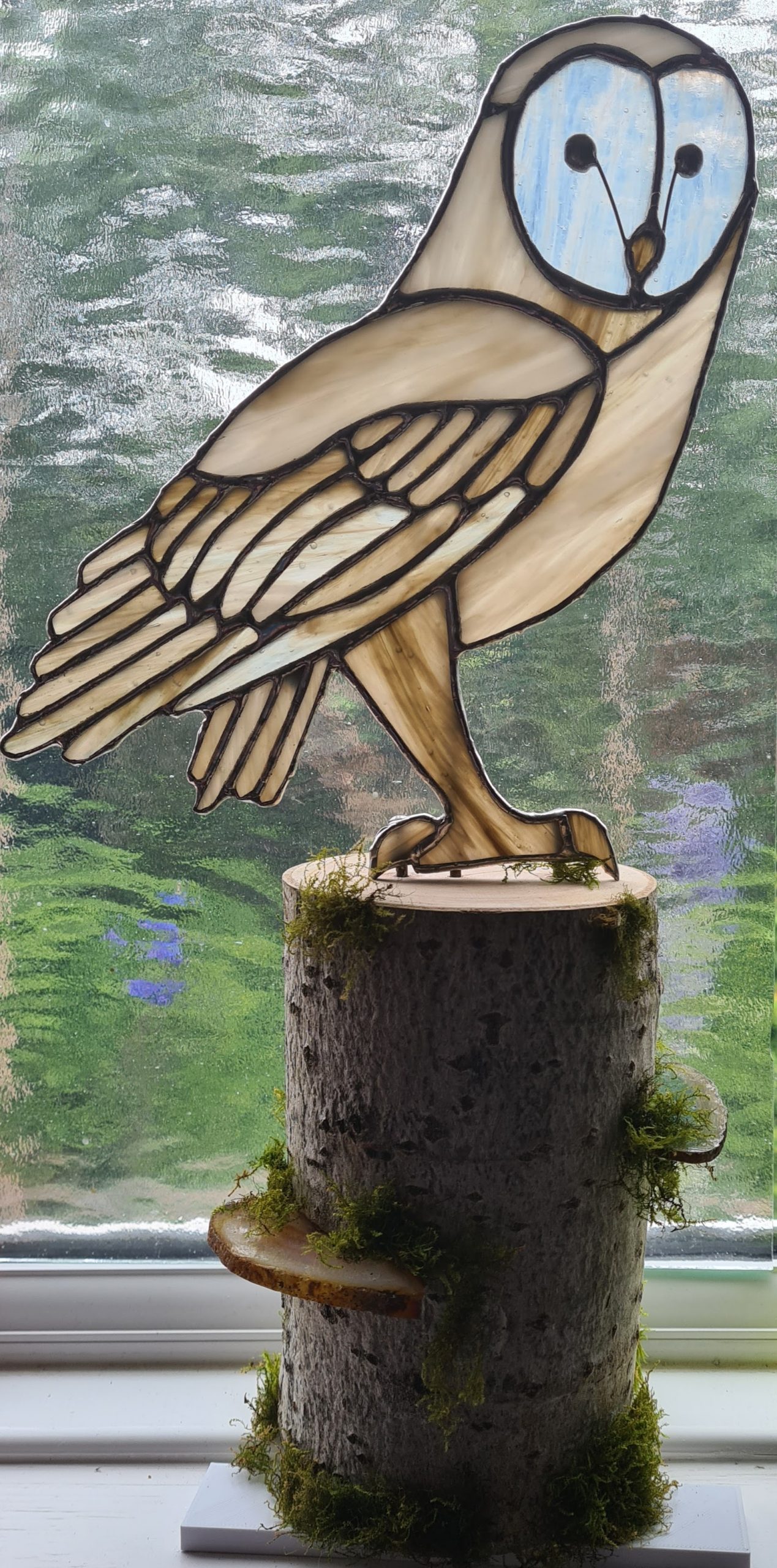 Stained glass barn owl on a tree stump, with agate slices to represent fungi