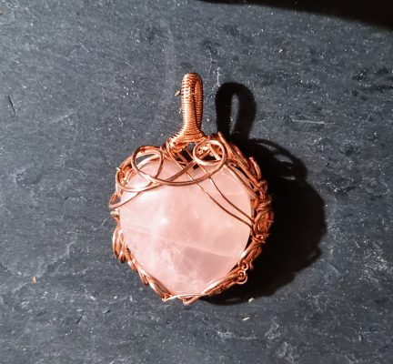 Rose quartz heart wrapped in copper to form a pendant