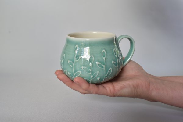 Porcelain wheel thrown mug with slip trailed design. Green celadon glaze. round mug hug.