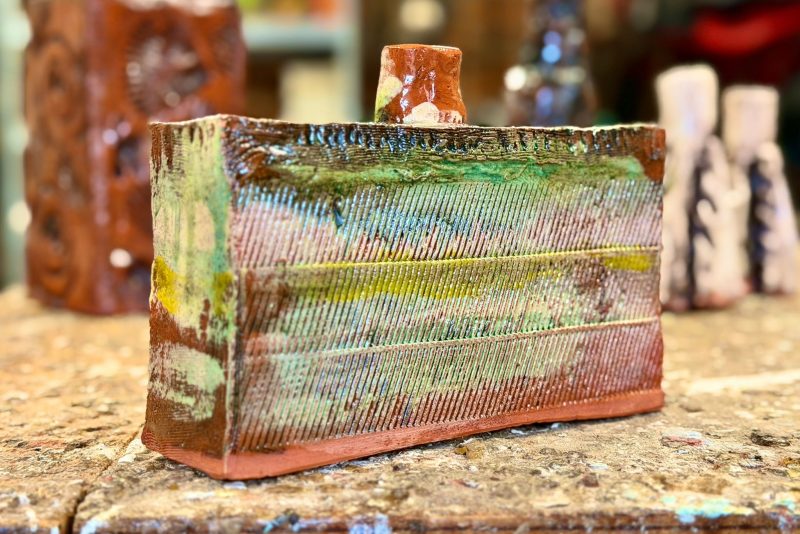 Farmer potter making hand-built earthenware using slips and washes, reflecting landscape, farm and garden using found objects.