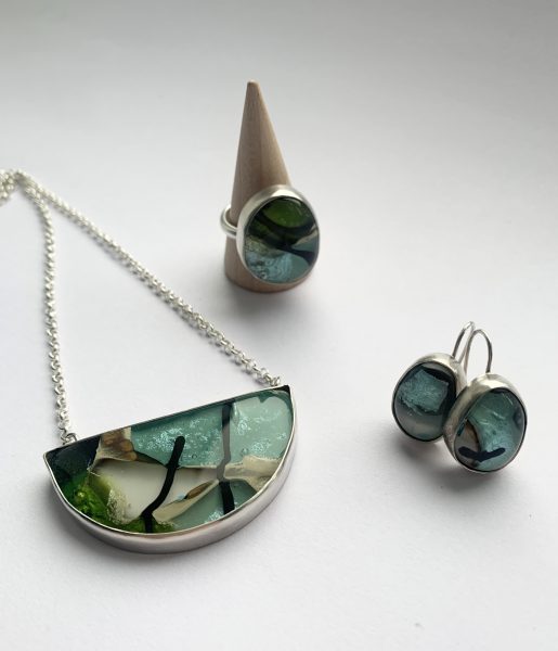 I create small batches of glass stones using combinations of transparent, opaque and reactive glass and fusing them in my kiln, using solar power when the sun decides to shine.  I design a setting for these stones, sometimes with semi-precious stones or found objects.  I make the settings myself in silver, bronze and brass to become distinctive, one-of-a-kind jewellery.  I will be taking part in Open Studios this year alongside Prue Pye.